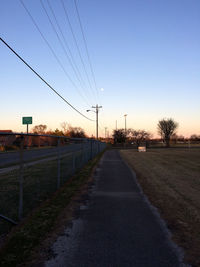 Empty road along landscape at sunset