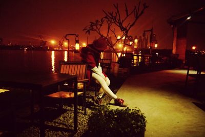 Woman standing in illuminated city at night