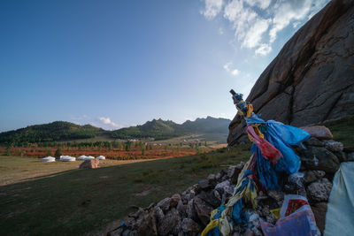 People on rock by land against sky