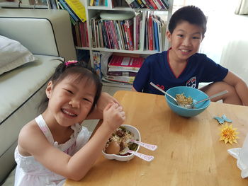 Portrait of happy friends sitting on table