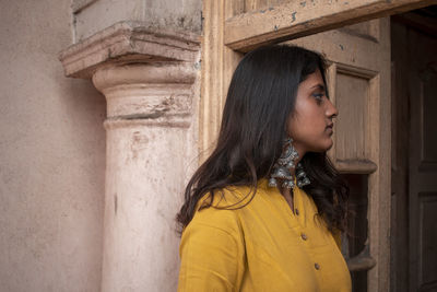 Portrait of a beautiful young woman standing at home