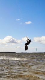 Man jumping in sea against sky