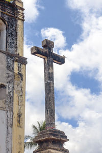 Low angle view of cross on building against sky