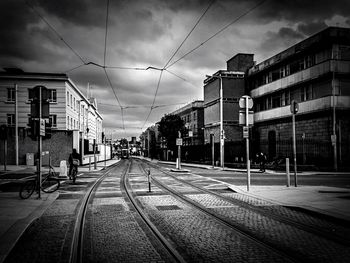 Railroad tracks against cloudy sky