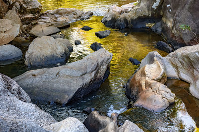 High angle view of stream flowing through rocks