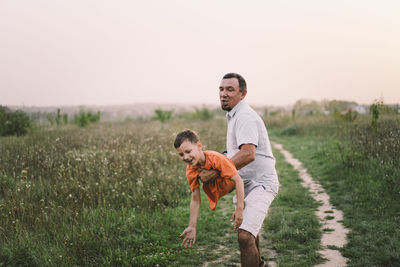 Happy fathers day. father with son are walking in the field.