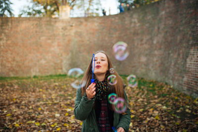 Happy young woman standing at park