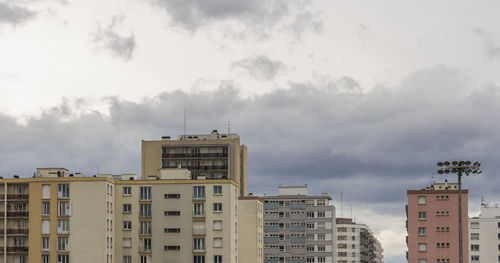 Low angle view of buildings against cloudy sky