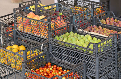 Stacks of crates of assorted fruits for sale at local market in early autumn