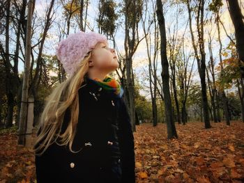 Cute girl standing against trees at forest