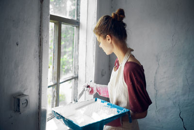 Young woman painting window