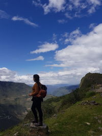 Full length of man standing on mountain against sky