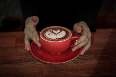 Woman holding coffee cup on table