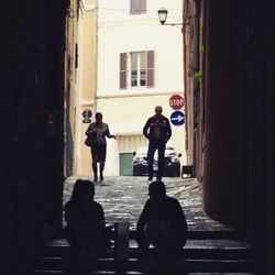 Rear view of silhouette man walking on street