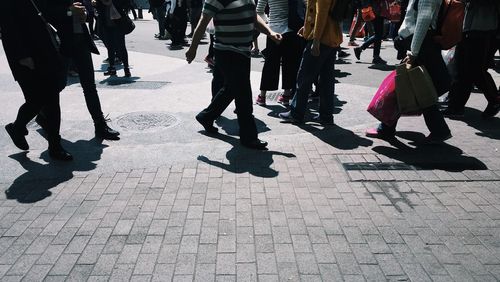 Low section of people walking on street