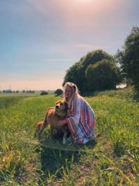 Woman with dog and blanket in field