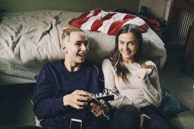 Portrait of smiling young woman using mobile phone at home