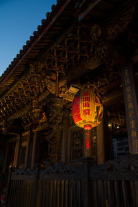 Low angle view of lantern hanging against building