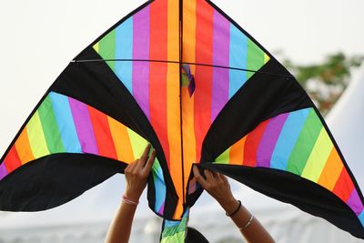 Close-up of hand holding multi colored umbrella