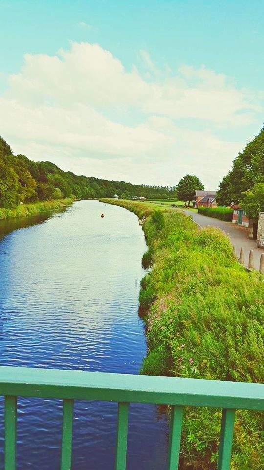 water, sky, tree, tranquil scene, tranquility, scenics, beauty in nature, river, nature, railing, cloud - sky, lake, mountain, plant, day, idyllic, green color, growth, cloud, canal