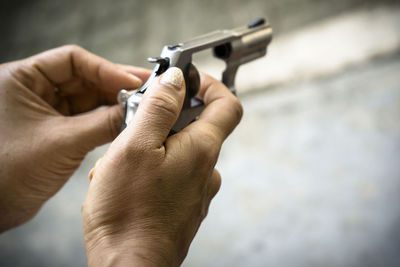 Close-up of man reloading pistol