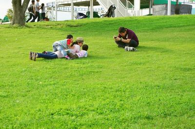 People sitting on grassy field in park