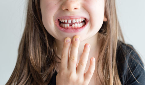 Close-up of happy girl with hand on white background