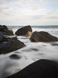 Rocks on beach against sky