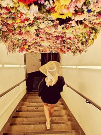 Full length rear view of woman standing on staircase