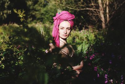 Portrait of woman standing against pink flowers