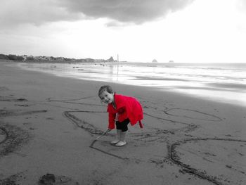 Full length of boy on beach against sky