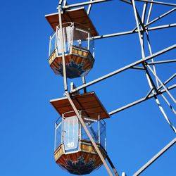 Low angle view of ferris wheel against clear blue sky