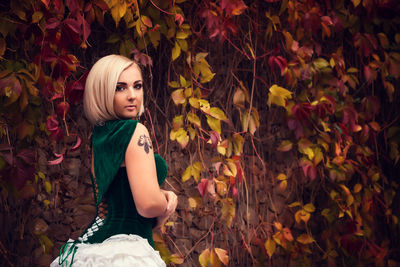 Portrait of young woman with autumn leaves