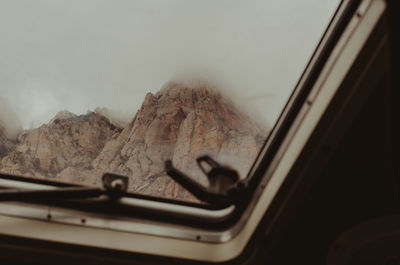 Close-up of car against sky seen through window