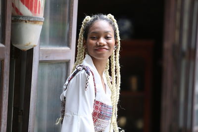 Portrait of smiling young woman with dreadlocks outdoors