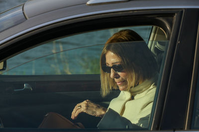 Portrait of young woman sitting in car