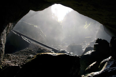 A foggy, dark cave entrance silhouette. cetatile ponorului cave, padis, romania