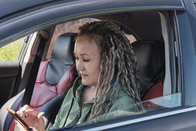 Portrait of young woman sitting in car