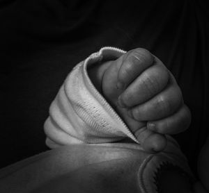 Midsection of baby against black background