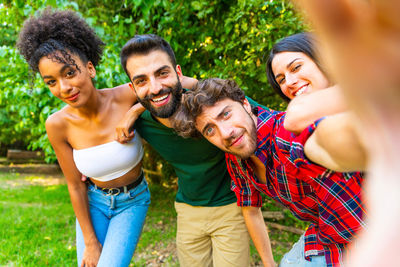 Cheerful friends taking selfie in back yard