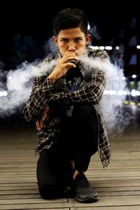 Full length of young man smoking outdoors