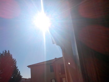 Low angle view of sunlight streaming through buildings