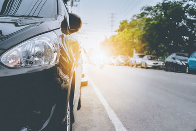 Close-up of yellow car on road