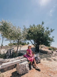 Young woman sitting on rock at park