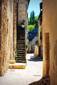 Steps amidst buildings against sky