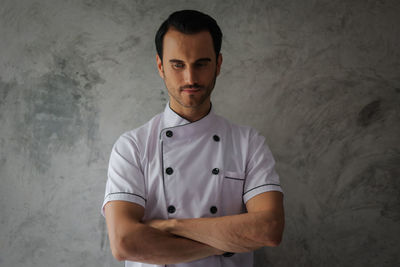 Chef standing against wall