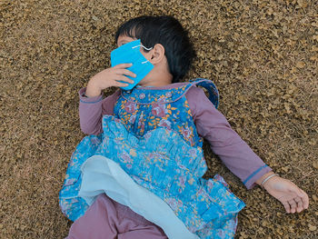 High angle view of woman sitting on field