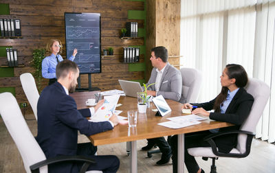 Side view of man using laptop at table