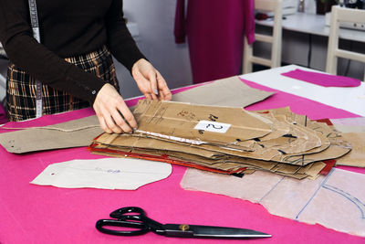 Sewing sustainable fashion industry. seamstress working with clothing and sewing pattern on table