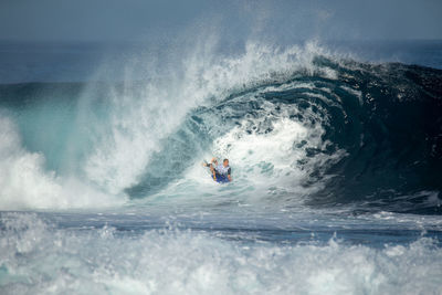 Man surfing in sea against sky